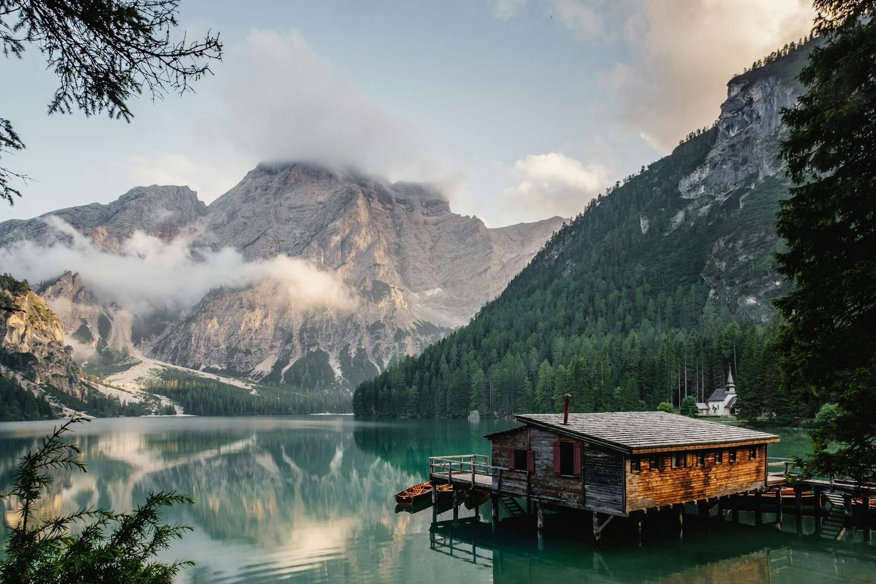 Misty mountains reflected in Lago di Braies, Italy.